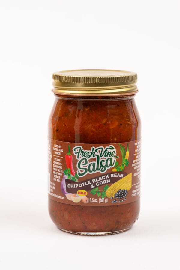 A jar of salsa with chili and other ingredients.