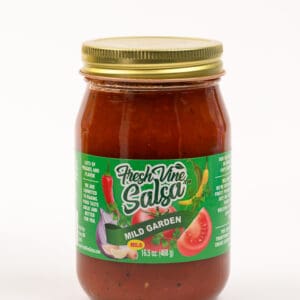 A jar of salsa with a green lid.