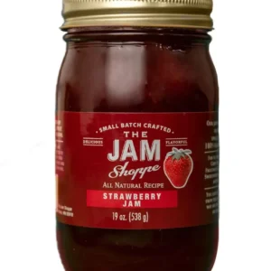 A jar of jam with the label " the jam shoppe strawberry jam ".