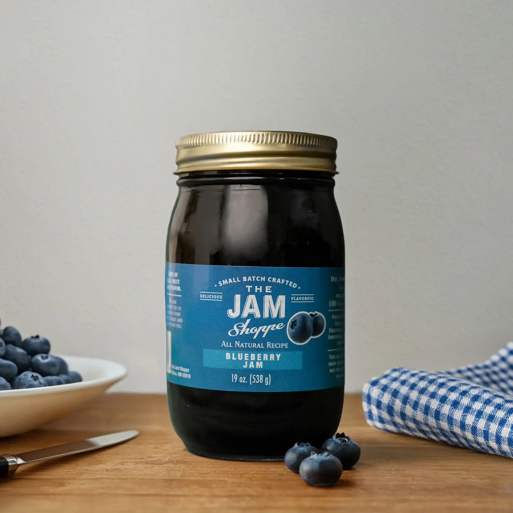 A jar of blueberry jam sitting on top of a table.